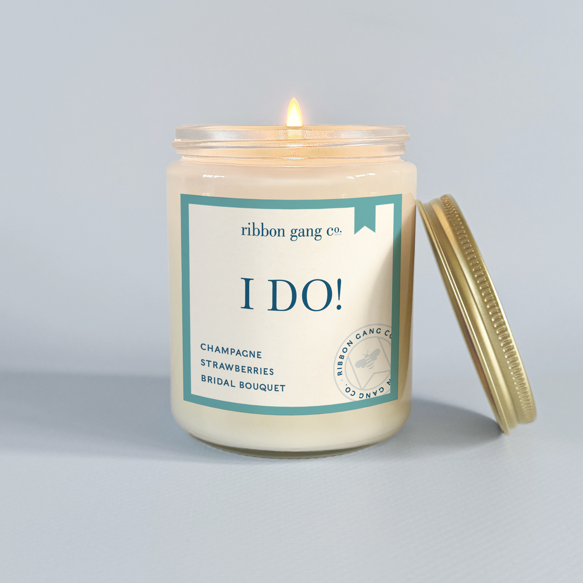Candle in a clear jar with an 'I Do!' label on a light blue background.