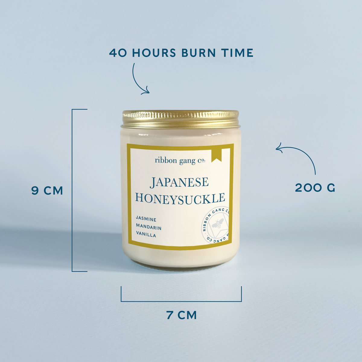 A candle jar labeled 'Japanese Honeysuckle' by ribbon gang co., shown on a light blue background with measurement callouts indicating 9 cm height, 7 cm width, 200 g weight, and 40 hours burn time.